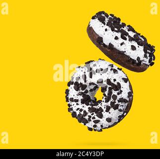 Two chocolate donuts isolated on yellow background. Stock Photo