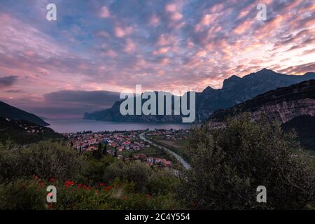panoramic sunset view with dramatic cloudy sky of Torbole at Lago di Garda (Lake Garda), Trentino, Italy; financial loss in tourism due to empty hotel Stock Photo