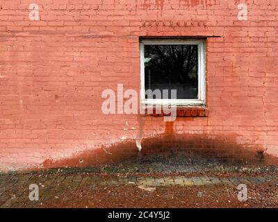 water leaking from window damaged alley brick building Stock Photo