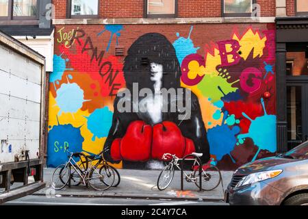 A spray painted mural of musician Joey Ramone on a red brick wall Stock Photo