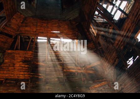 Beams of light in old abandoned wooden church Stock Photo