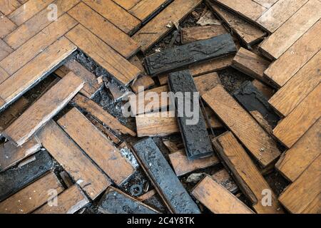 Damaged wooden floorboard, wood parquet flooring with displaced planks, old floor in an abandoned building room Stock Photo