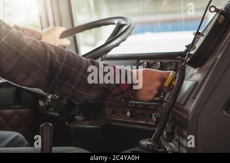 Semi Truck Male Driver Inside Of Vehicle Behind Steering Wheel. Transportation Industry Concept. Stock Photo