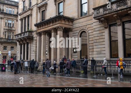 Glasgow, Scotland, UK. 29th June, 2020. Shoppers standing in line outside the Apple store on Buchanan Street as shops are now allowed to reopen for business today with the further easing of the coronavirus lockdown rules. Credit: Skully/Alamy Live News Stock Photo