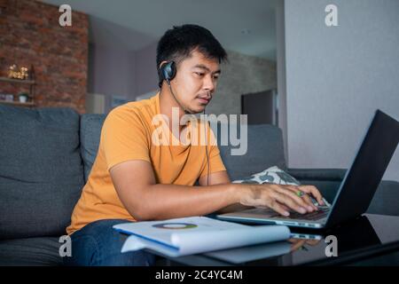 Asian businessmen is using notebook computers and wear headphones for online meetings and working from home. Stock Photo