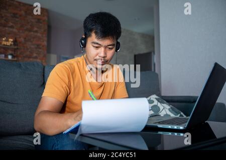 Asian businessmen is using notebook computers and wear headphones for online meetings and working from home. Stock Photo