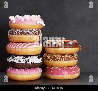 Stack of colorful donuts on a stone background Stock Photo