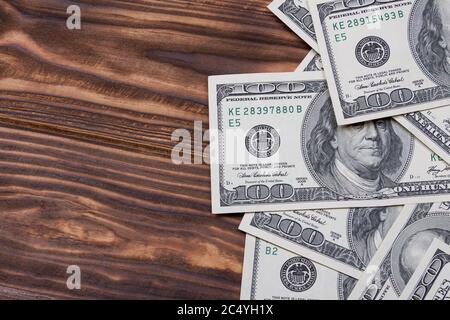 100 US Dollars Banknotes with Blank Space for Yours Design on a wooden background Stock Photo