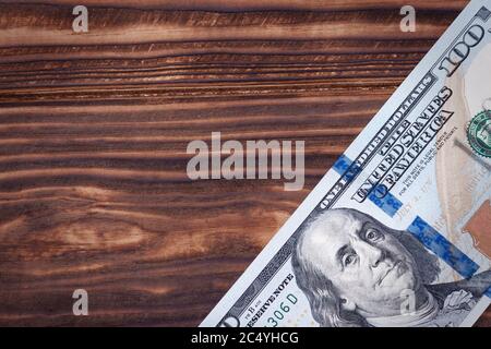 New 100 US Dollars Banknote with Blank Space for Yours Design on a wooden background Stock Photo