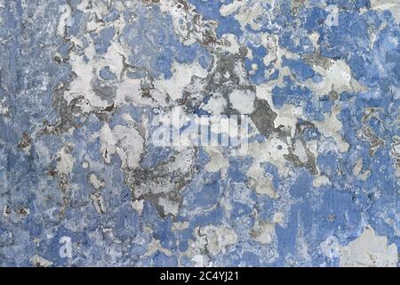 Old blue and white wall texture. Texture of the old worn wall with several layers of white and blue paint. Stock Photo