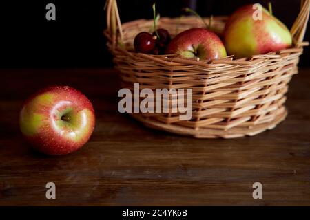 Braided basket with red apples on a black background Stock Photo