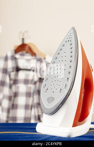 Iron on Ironing Board Against a White Wall extreme closeup Stock Photo