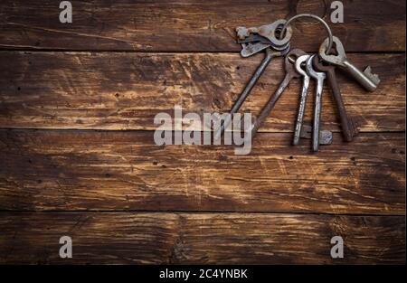 Bunch of old vintage keys on wooden background, top view with space for text. Safety and security concept, copy space Stock Photo