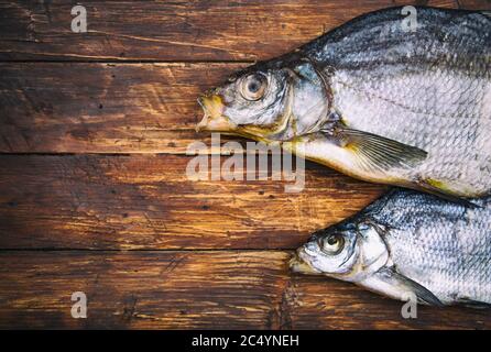 Two dried salted fish bream on a wooden table, vintage style, top view, text space Stock Photo