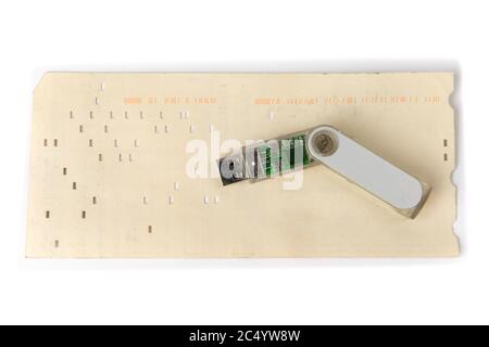 the history of computer data storage, vintage 80 column computer punch card and a modern USB memory key Stock Photo