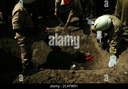 Men from Bangladesh Fire Service and Civil Defense, recovering dead bodies of army officers from mass grave. The military and Fire service men are sea Stock Photo