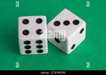lucky seven - a pair of dice on a green background showing four and three Stock Photo