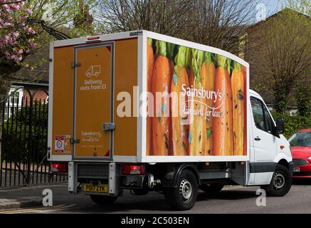 A delivery van belonging to Sainsbury's supermarket parked on a road making a delivery to its online customers. Stock Photo