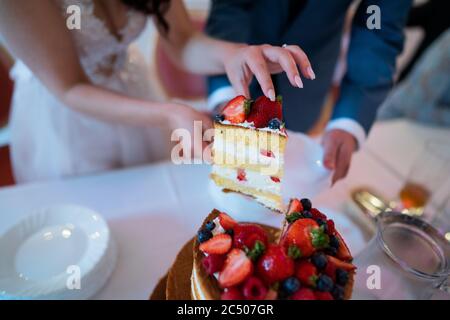 Newlyweds cutting a wedding cake Stock Photo