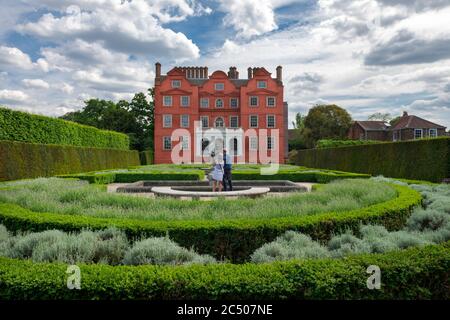 A couple in the formal garden of Kew Palace sightseeing. It is a British Royal palace in Kew Gardens. Stock Photo