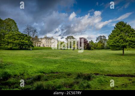 Kenwood House and the surrounding grounds in Spring time with lush green grass and trees on a beautiful day with blue sky clouds. Stock Photo