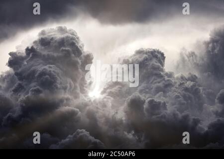 Sun rays breaking through the dark clouds. Clouds background. Dramatic grey clouds Stock Photo