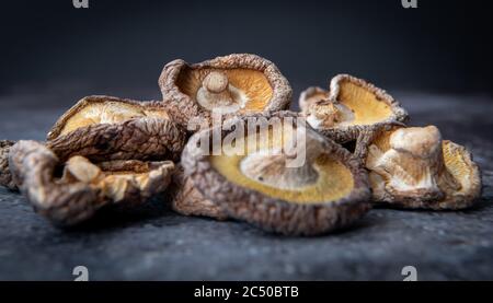 A pile of dried shiitake mushrooms with a dark background. Stock Photo