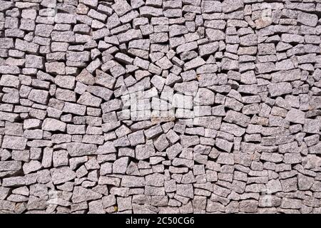 Structure. Close-up of the surface of an effective and very durable fence made of split granite. Stock Photo
