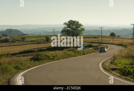 Transportation background. Car going on curvy village road Stock Photo