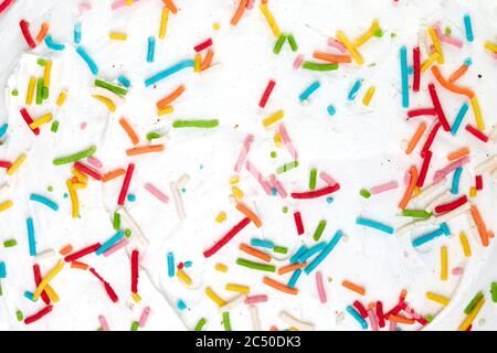 Candy sprinkles confetti. Sugar sprinkle dots. Sweet confetti on white glaze background. Cupcake, donuts, dessert, sugar, bakery background. Stock Photo