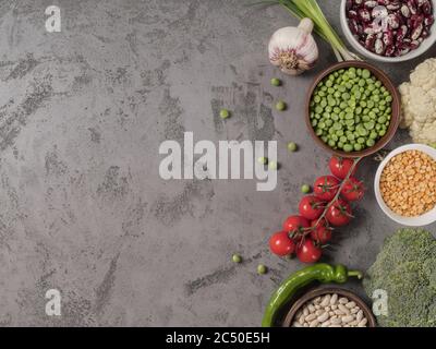 Organic vegetables and assorted beans on a grey background. Stock Photo