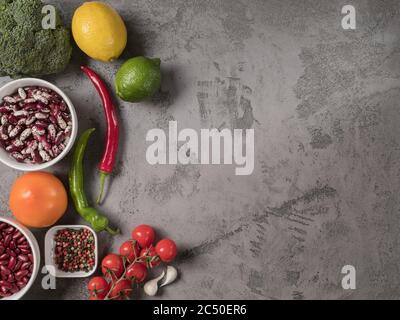 Organic vegetables, beans and spices on grey background. Stock Photo