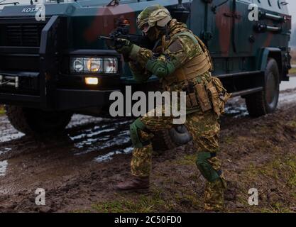 soldier moves undercover with an armored car on the road Stock Photo