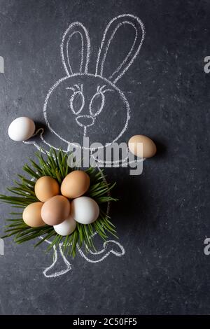 Easter bunny with eggs. Green grass and eggs. Chalk drawn bunny with real grass and eggs. Stock Photo