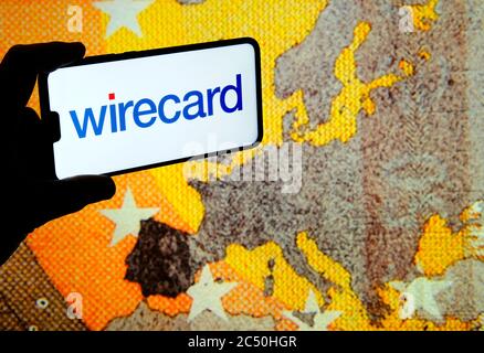 Stone /United Kingdom - June 29 2020: Wirecard logo on smartphone and euro banknote large image on the blurred background screen. Real photo, not a mo Stock Photo