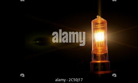 Burning lightbulb filament. Electric tungsten light bulb on a black background Stock Photo