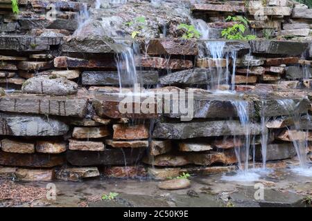 Artificial waterfall in the garden cascade made with stones Stock Photo
