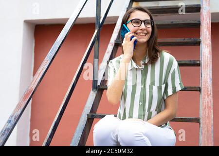Woman in shirt and glasses talking on the phone. Woman calling with her mobile. Stock Photo
