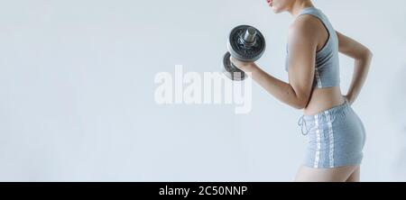 Gym background. Fit girl works out with vintage weights Stock Photo