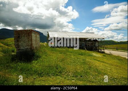 The small church of the Madonna della Cona, near Castelluccio di Norcia, surrounded by reinforcement structures to remedy earthquake damage. Stock Photo
