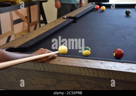 Black billiard table, Playing billiard - Close-up shot of a man playing billiard Stock Photo
