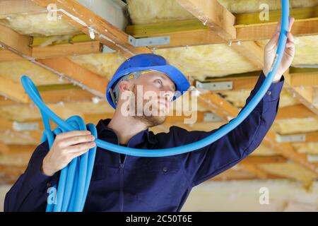 a plumber checking ceiling pipes Stock Photo