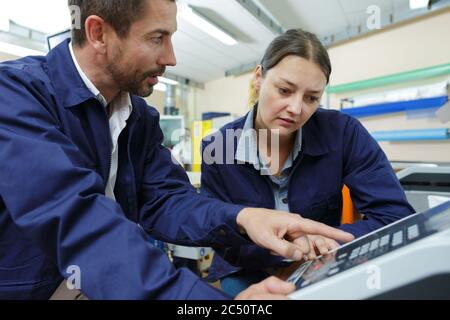 young woman operating a machine Stock Photo