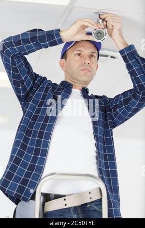 mature contractor installing cctv camera Stock Photo