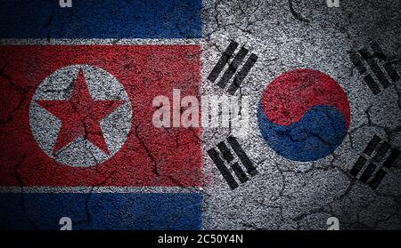 3D rendering of dual North Korea and South Korea flags painted on concrete wall in grunge effect with deep cracks to illustrate the broken or tense re Stock Photo