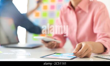 Graphic designers team work together with UX UI designer planning application template layout mobile phone prototype, User experience concept. Stock Photo