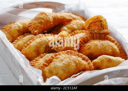 close-up of delicious deep fried Buffalo Chicken Empanadas in a rustic wooden serving tray, horizontal view from above Stock Photo