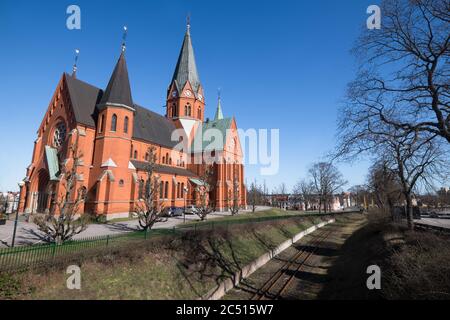 The Sankt Petri Kyrka or Saint Peter Church next to the metro line in  Västervik (Vastervik) in Sweden. Blue sky Stock Photo