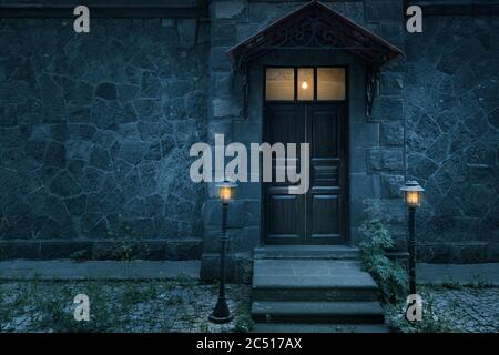 Old rustic classical stone house and brown vintage wooden door with wrought iron. High quality photo Stock Photo