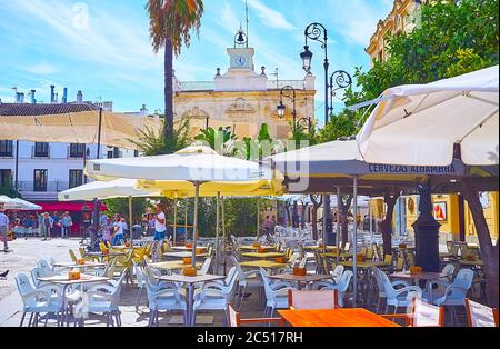 SANLUCAR, SPAIN - SEPTEMBER 22, 2019: The tables and sunshades of numerous outdoor cafes, located in Plaza del Cabildo square, on September 22 in Sanl Stock Photo